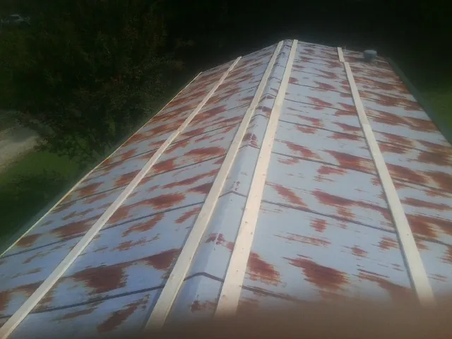 Rusted metal roof panels with new wood purlins before replacement — Storm Damage Roof Repair in Manlius by Roofing Brothers