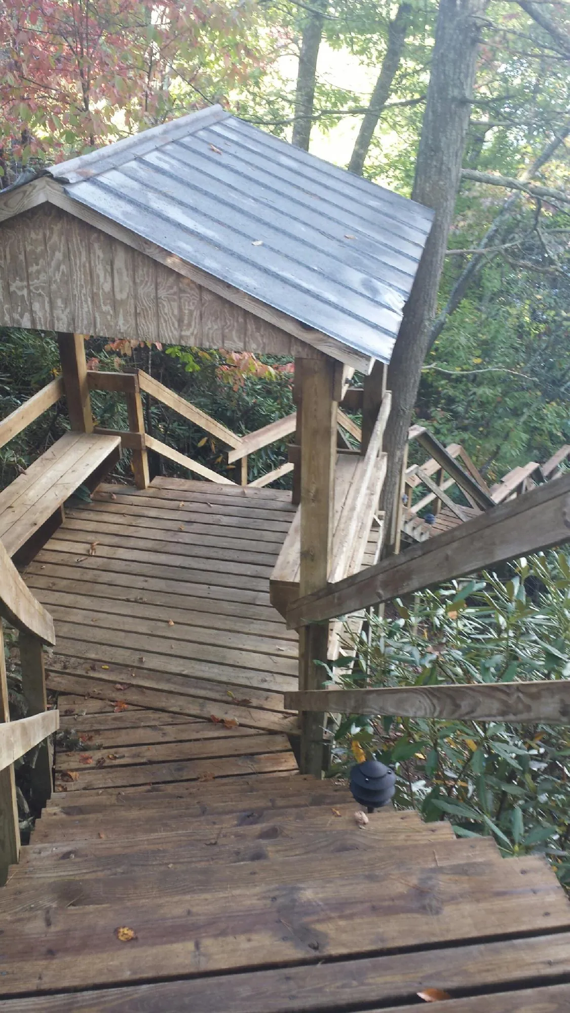 Metal roofed shelter over wooden steps on a wooded walkway — Skylight Repair & Installation work by our crew in Manlius