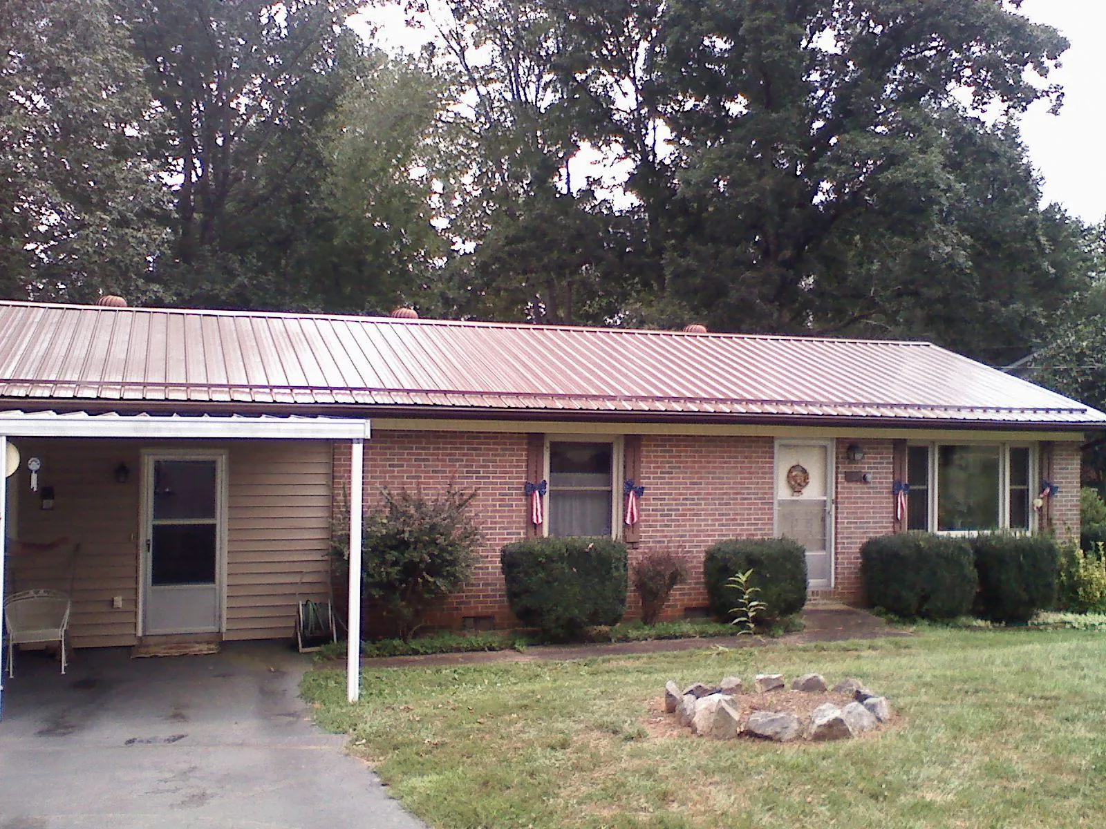 Bronze metal roof and carport on a brick ranch home — Roof Repair work by our crew in Manlius